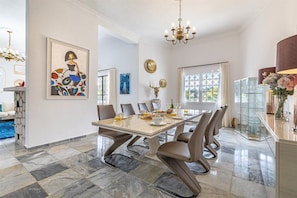 A dining area with a marble floor, a large table, and modern chairs. - Luxury villa with private tennis & heated pool (Mijas)