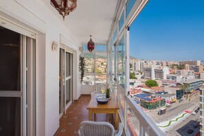 Un balcón con mesa, sillas y vistas de la ciudad.