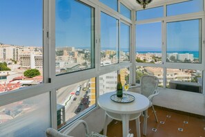 Un balcon avec une table, des chaises et une bouteille de champagne.