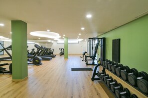 Ein Fitnessstudio mit Cardiogeräten, Gewichten und Kurzhanteln.