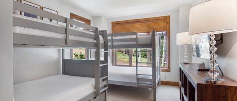 Una habitación con literas, un escritorio y una lámpara.