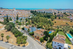 A residential area with multiple houses, a swimming pool, and a road.