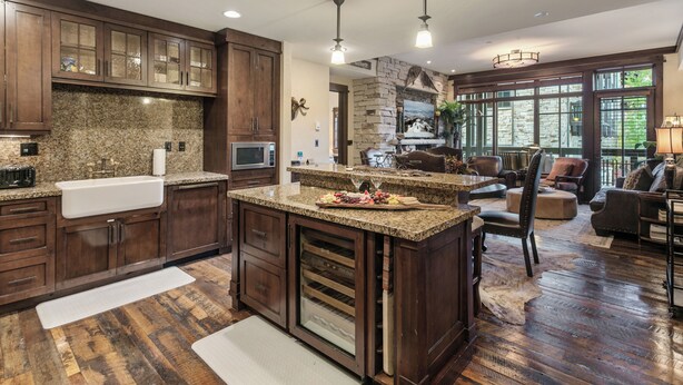 A spacious kitchen with granite countertops, wooden cabinets, and a large island.