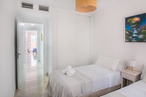 A hotel room with a bed, a nightstand, a lamp, and a painting on the wall. - Seaview apartment with terrace. Walk to beach (Benalmadena)