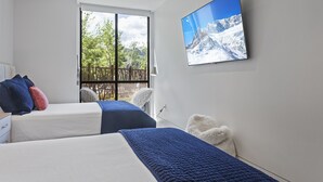 A modern hotel room with two beds, a large window with a view of trees, and a flat-screen TV on the wall. - One Empire Pass Lodge at Deer Valley Resort - Two Bedroom Residence #105 2 Condo (Park City)