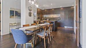 A modern kitchen with wooden cabinets, a central island, and pendant lighting. - One Empire Pass Lodge at Deer Valley Resort - Two Bedroom Residence #105 2 Condo (Park City)