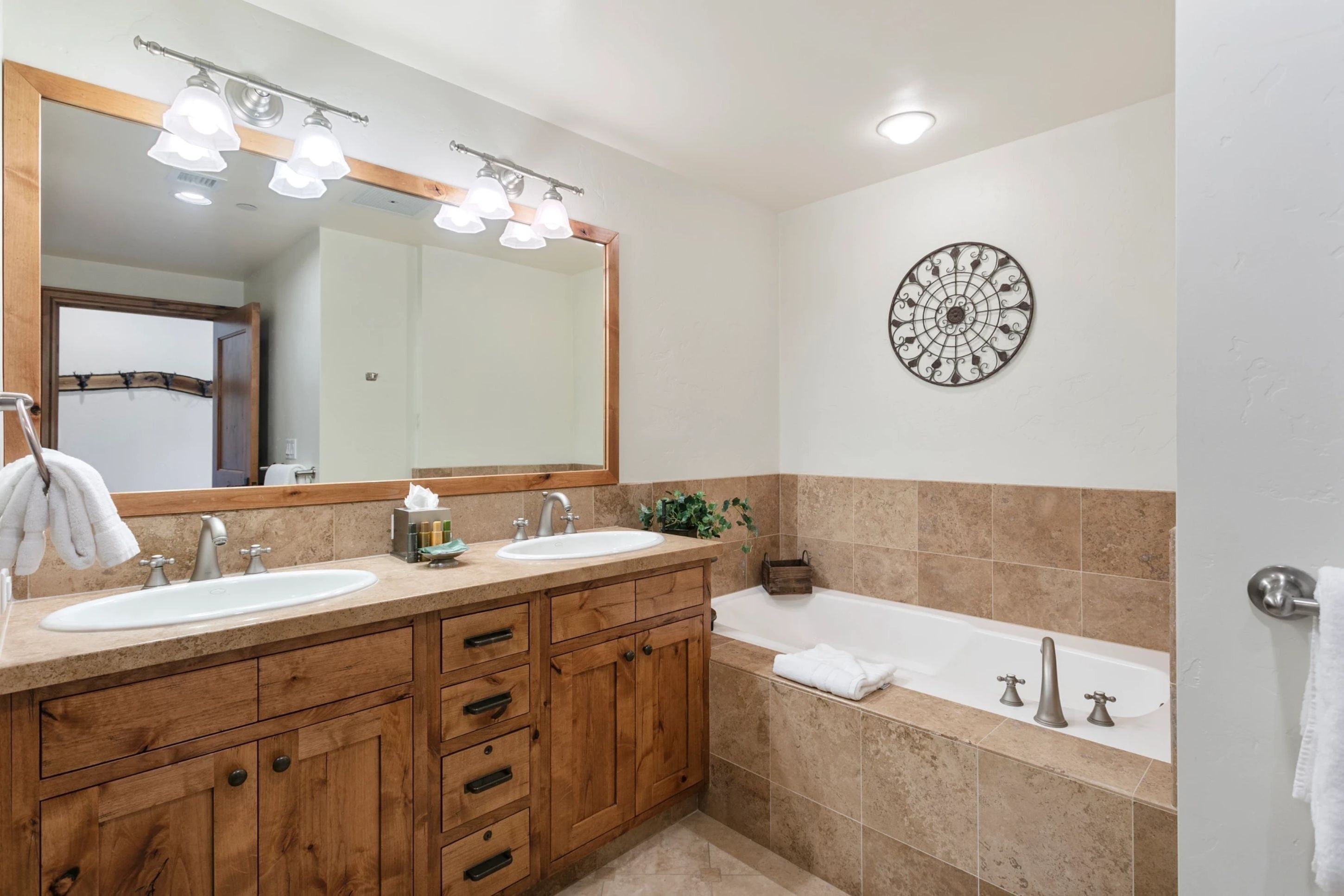 Un baño moderno con dos lavabos, un espejo grande y una bañera.