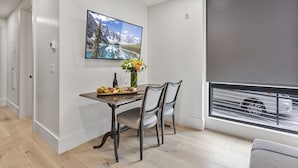 Un comedor con una mesa, sillas, un florero con flores y un cuadro en la pared.