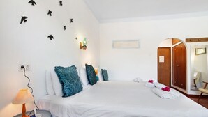 A hotel room with a bed, a bedside table with a lamp, a mirror, and a wardrobe. - Private Refuge in a Quiet Area with Shared Pool (São Brás de Alportel)