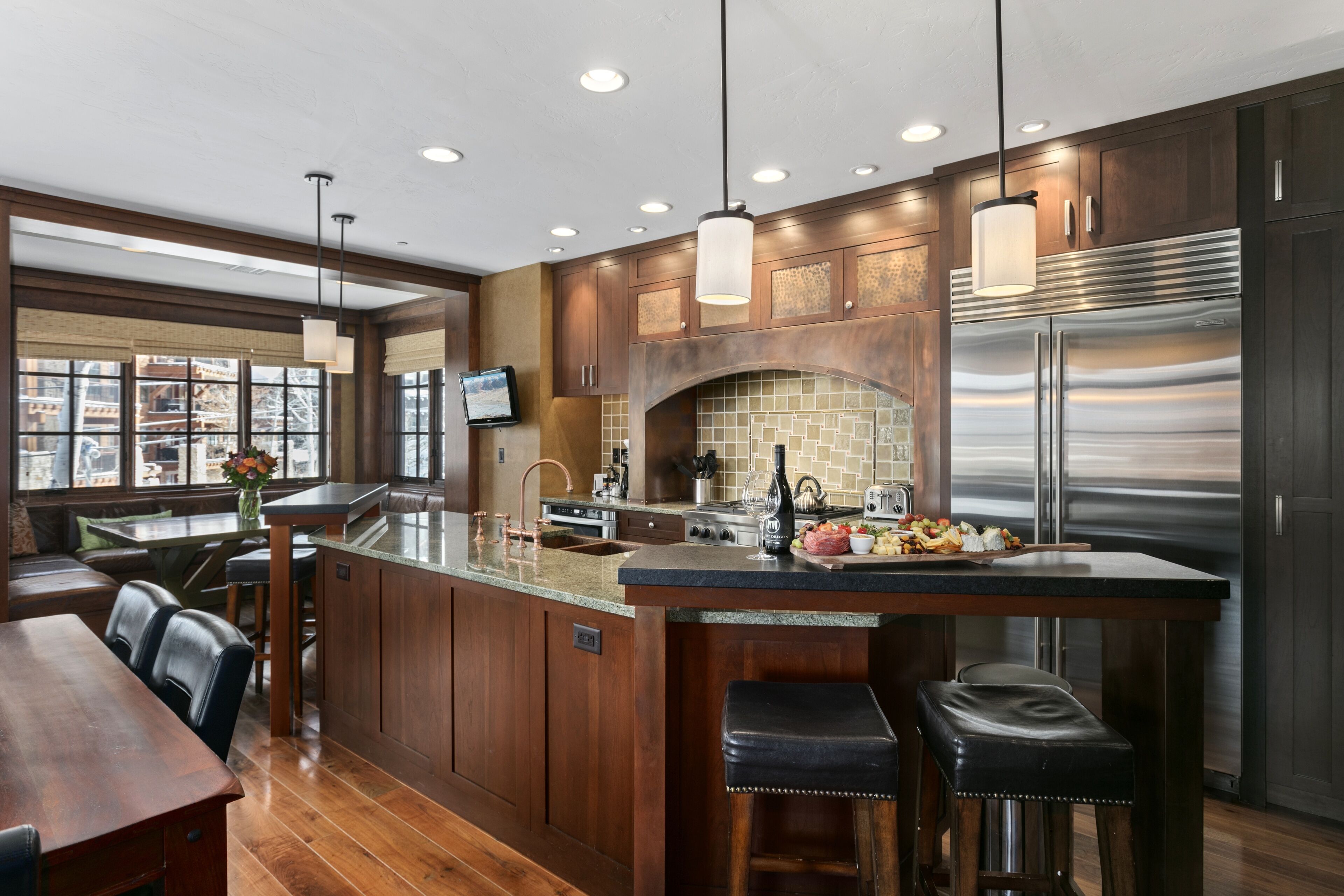 A modern kitchen with a large island, stainless steel appliances, and wooden cabinetry.