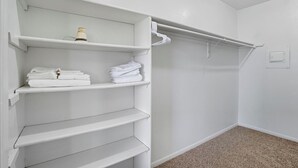 A white closet with shelves and hanging space, a light switch, and a carpeted floor. - Apt. In college station TX. Mins to major hospitals and A&M U (College Station)