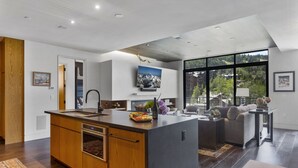 A modern kitchen with a central island, built-in oven, and a large window offering a view of a mountainous landscape. - One Empire Pass at Deer Valley Resort - Three Bedroom Residence #402 3 Condo (Park City)
