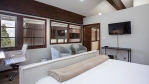 A hotel room with a bed, a desk, two chairs, a TV, and large windows. - Stag Lodge at Deer Valley Resort - Three Bedroom Residence with Spa #9 3 Condo (Park City)
