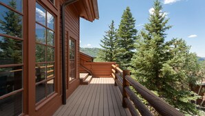 A wooden deck with a railing, large windows, and a view of trees and hills. - Stag Lodge at Deer Valley Resort - Three Bedroom Residence with Spa #9 3 Condo (Park City)