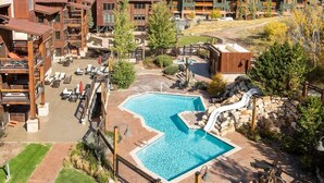 A resort with a central pool, outdoor seating, and a waterfall feature. - Silver Baron Lodge Hotel Room by Deer Valley Resort (Park City)