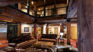 A spacious lobby with leather sofas, a high ceiling, and a view of the upper floor. - Silver Baron Lodge 2 Condo Bedroom with Spa by Deer Valley Resort (Park City)