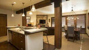 A spacious kitchen with a central island, wooden beams, and pendant lighting. - Silver Baron Lodge 2 Condo Bedroom with Spa by Deer Valley Resort (Park City)