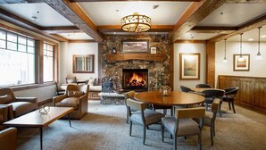 A cozy lounge area with a stone fireplace, comfortable seating, and a large window providing natural light. - Grand Lodge - 1 Bedroom Studio #205 - Ski-in/ski-out by Deer Valley Resort (Park City)