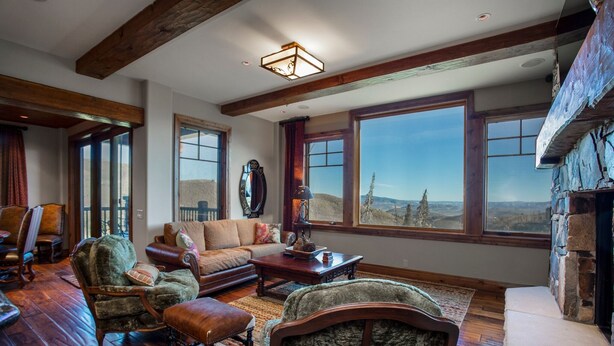 A spacious living room with large windows, wooden beams, and a fireplace. - Grand Lodge - Three Bedroom Condo #301 - Ski-in/ski-out by Deer Valley Resort (Park City)