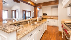 A kitchen with a granite countertop, white cabinets, a built-in oven, and a microwave. - Grand Lodge - Five Bedroom Condo #402 - Ski-in/ski-out by Deer Valley Resort (Park City)