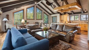 A spacious living room with a leather sofa, a glass coffee table, and a large window. - Queen Esther at Deer Valley Resort - Two Bedroom Condo with Hot Tub #2346 2 Condo (Park City)