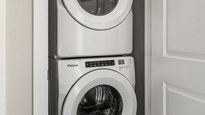A compact laundry room with two stacked Whirlpool front-loading washing machines. - Lion s Den - 3bed - 5guest - 2 Smarttv - Hospital (Calgary)