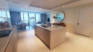 Una cocina moderna con una isla central, un área de comedor con sofá y un amplio ventanal con vistas.