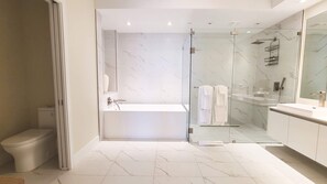 A modern bathroom with a glass-enclosed shower, a white bathtub, and a large mirror. - NEW Amrit Resort Oceanview Retreat (Singer Island)