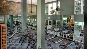A modern gym with various cardio machines, weightlifting equipment, and a checkered floor.