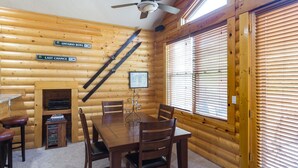 A wooden cabin interior with a dining table, chairs, a ceiling fan, and wooden walls. - Comstock Lodge - Two Bedroom Condo with Hot Tub #306 by Deer Valley Resort (Park City)