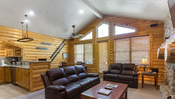 A log cabin interior with a living area, a fireplace, a kitchen, and a staircase. - Comstock Lodge - Two Bedroom Condo with Hot Tub #306 by Deer Valley Resort (Park City)