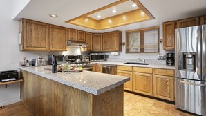 A modern kitchen with wooden cabinets, stainless steel appliances, and a granite countertop. - Aspenwood at Deer Valley Resort - Three Bedroom Condo with Hot Tub #1305 3 Condo (Park City)