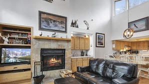 A modern living room with a fireplace, leather sofa, and a television. - Aspenwood at Deer Valley Resort - Three Bedroom Condo with Hot Tub #1305 3 Condo (Park City)