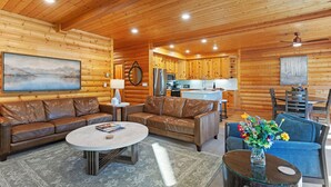 L’intérieur d’une cabane en rondins comprend un salon, une cuisine et un coin repas.