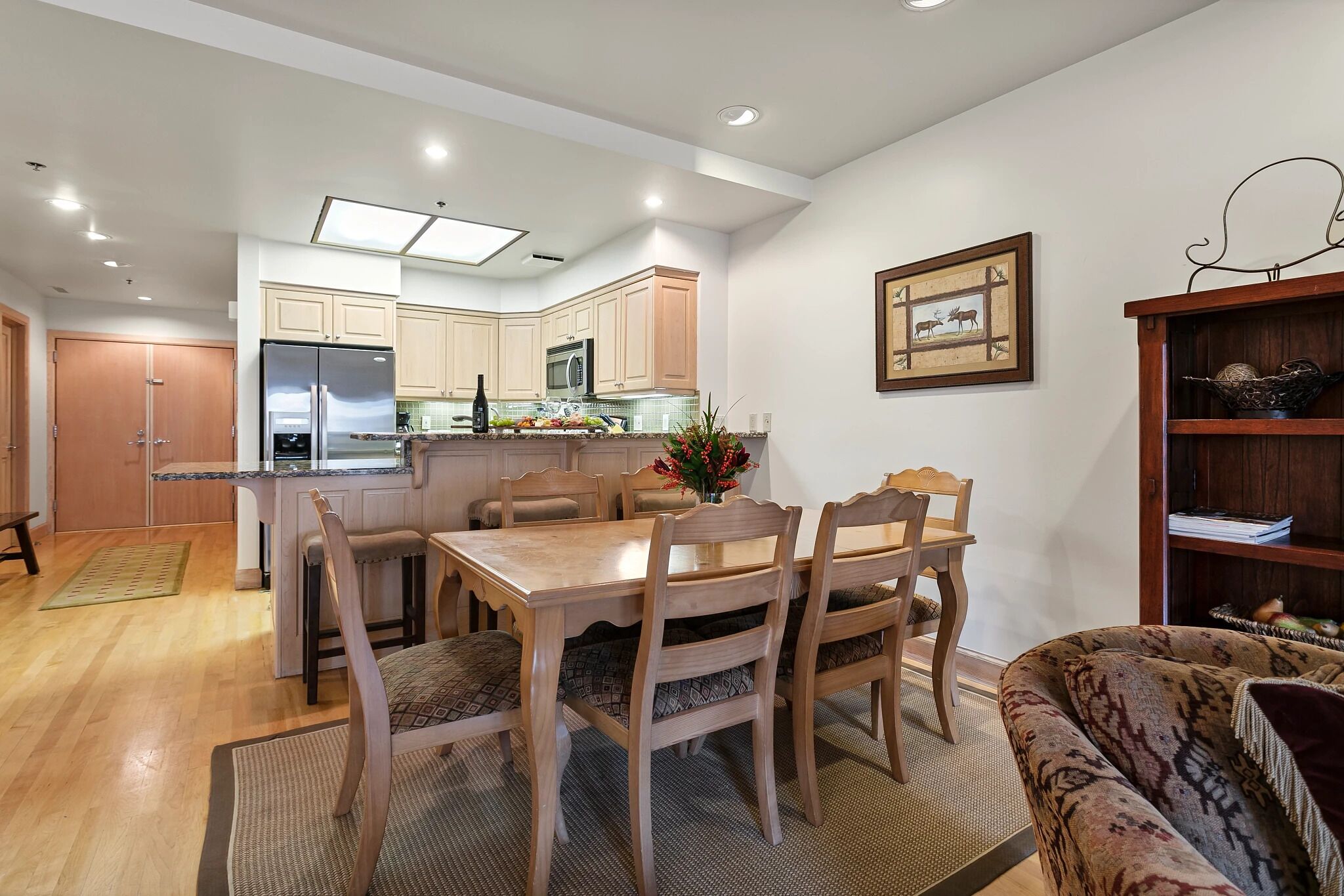 Una cocina moderna con una isla central, una mesa de comedor de madera y sillas.