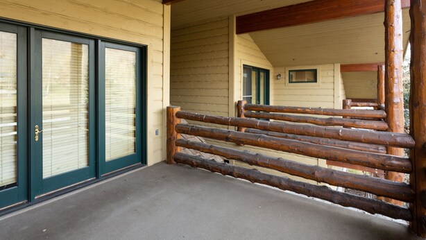 A wooden cabin with a porch, large windows, and a log railing. - Bristlecone at Deer Valley Resort - Three Bedroom Condo with Loft and Hot Tub #504 3 Condo (Park City)