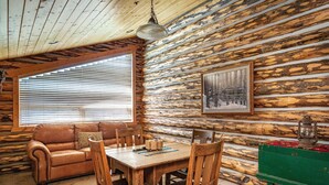 A rustic cabin interior with a wooden dining table, chairs, a leather sofa, and a green dresser. - Bristlecone at Deer Valley Resort - Three Bedroom Condo with Loft and Hot Tub #504 3 Condo (Park City)
