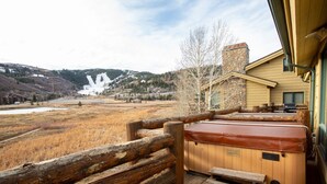 A wooden deck with a hot tub and a wooden bench, overlooking a snowy mountain and a valley. - Bristlecone at Deer Valley Resort - Three Bedroom Condo with Loft and Hot Tub #504 3 Condo (Park City)