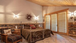 A cozy bedroom with a bed, a chair, a nightstand, and a wall-mounted lamp. - Bristlecone at Deer Valley Resort - Three Bedroom Condo with Loft and Hot Tub #504 3 Condo (Park City)
