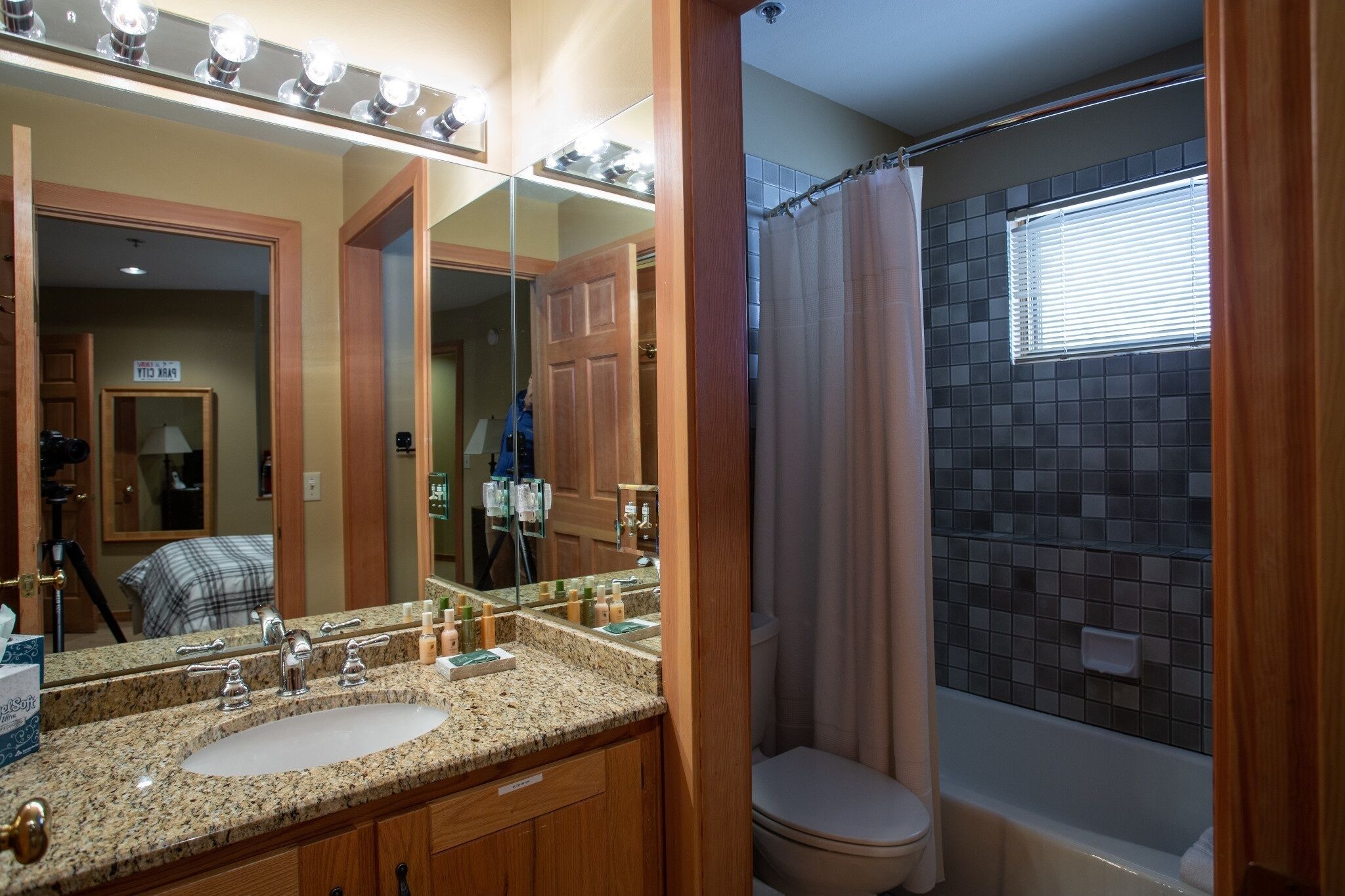 A bathroom with a vanity, sink, mirror, and a shower area with a curtain.