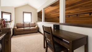 A cozy room with a brown leather sofa, a wooden desk, and a large window. - Lakeside at Deer Valley Resort - Two Bedroom Condo #1679 2 Condo (Park City)