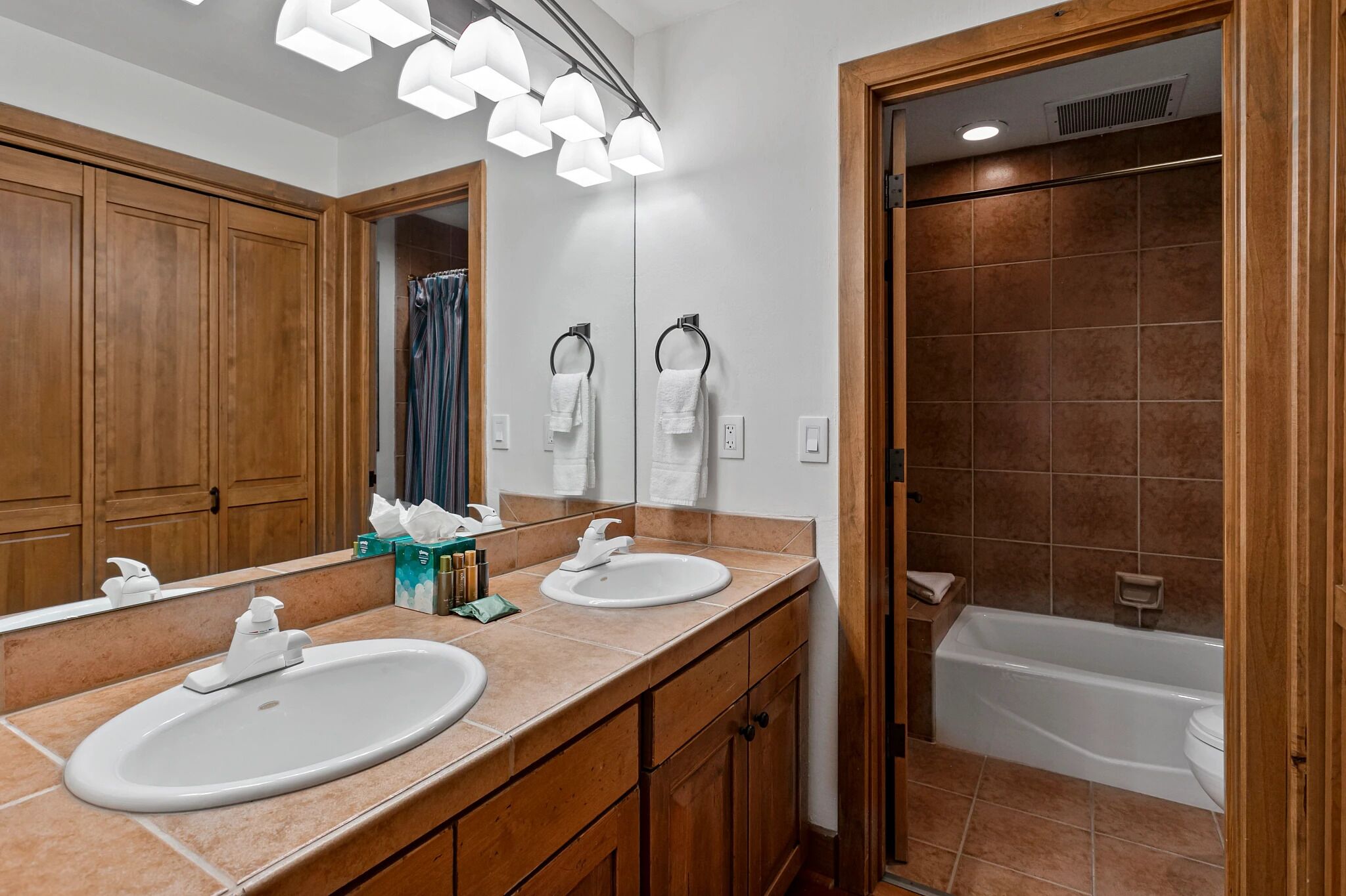 Un baño con dos lavabos, un espejo y una ducha.