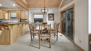 A kitchen with wooden cabinets, a dining table with chairs, and a chandelier. - Boulder Creek at Deer Valley Resort - Three Bedroom Condo with Hot Tub #1119 3 Condo (Park City)