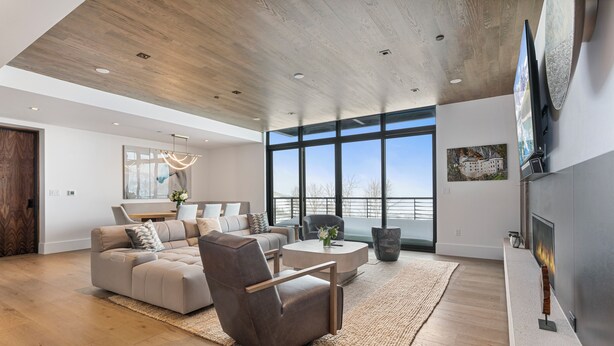 A spacious living room with a large window, a fireplace, and a modern sofa set. - Argent at Deer Valley Resort - Three Bedroom Deluxe #405 3 Condo (Park City)