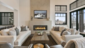 A modern living room with a fireplace, sofas, and a coffee table.