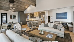 A spacious living area with a modern kitchen, a dining area, and a seating area with sofas and a coffee table.