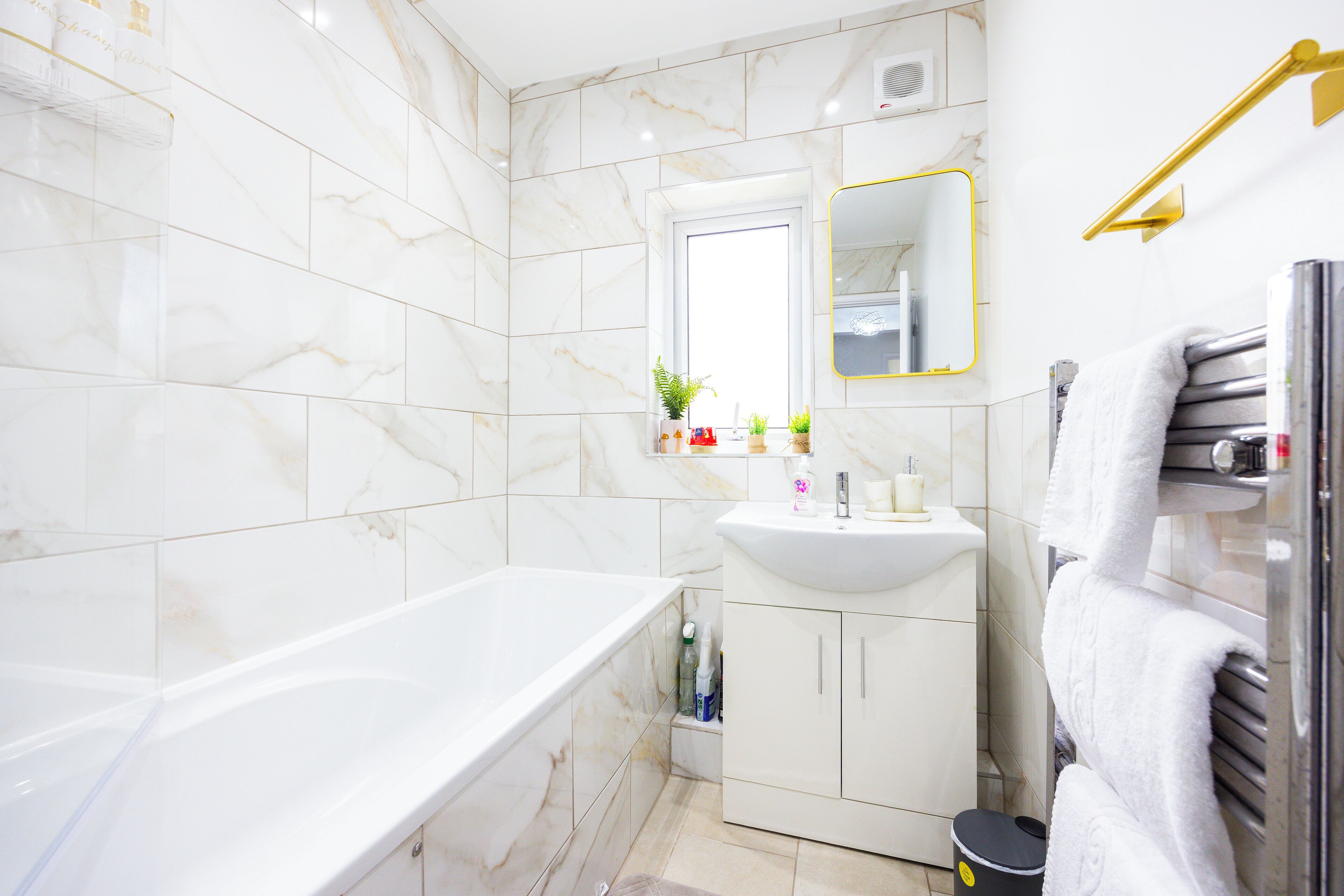 Un baño moderno con bañera, lavamanos y espejo.
