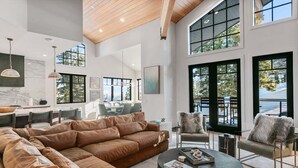 A spacious living area with a large brown leather sectional sofa, a round coffee table, and a seating area with chairs and a fireplace. - Stag Lodge at Deer Valley Resort - Four Bedroom with Spa #30 4 Condo (Park City)