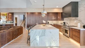 A modern kitchen with marble countertops, wooden cabinets, and a central island. - Stag Lodge at Deer Valley Resort - Four Bedroom with Spa #30 4 Condo (Park City)