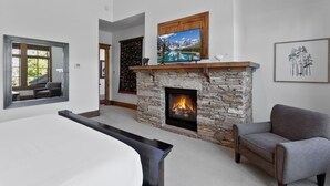 A modern living room with a stone fireplace, a large window, and a gray sofa. - Lookout at Deer Valley Resort - Four Bedroom Residence with Spa #6559 4 Condo (Park City)